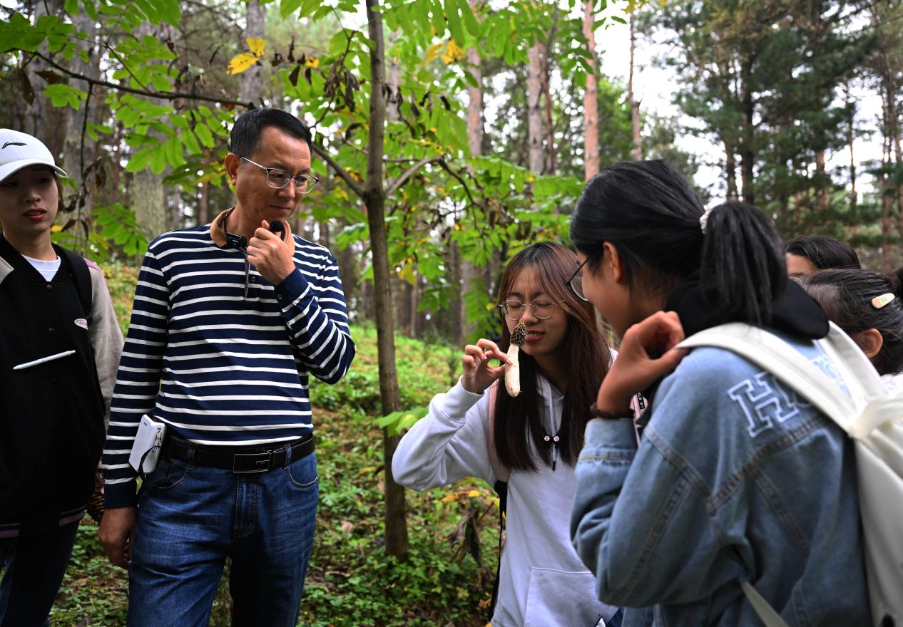 王占斌老師給同學(xué)們講解辨識(shí)蘑菇。（學(xué)校供圖）.jpg