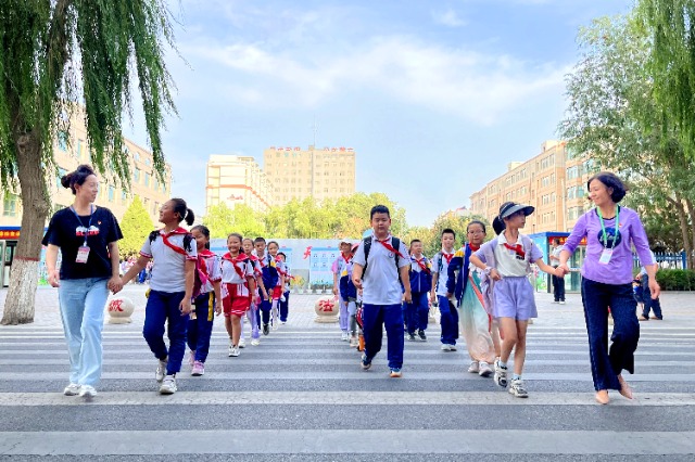 01 臨澤縣城關(guān)小學(xué)“紅燭先鋒”護(hù)學(xué)崗教師護(hù)送學(xué)生放學(xué)。謝靜 攝.jpg