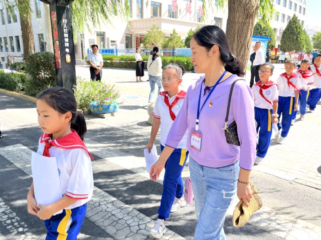 02 臨澤縣城關(guān)小學(xué)“紅燭先鋒”護(hù)學(xué)崗教師護(hù)送學(xué)生放學(xué)。謝靜 攝.jpg