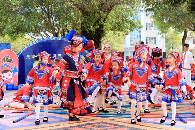 圖4：4月9日，在廣西柳州市融安縣實(shí)驗(yàn)小學(xué)校園，一名老師帶著學(xué)生跳竹竿舞。（譚凱興 攝）.JPG